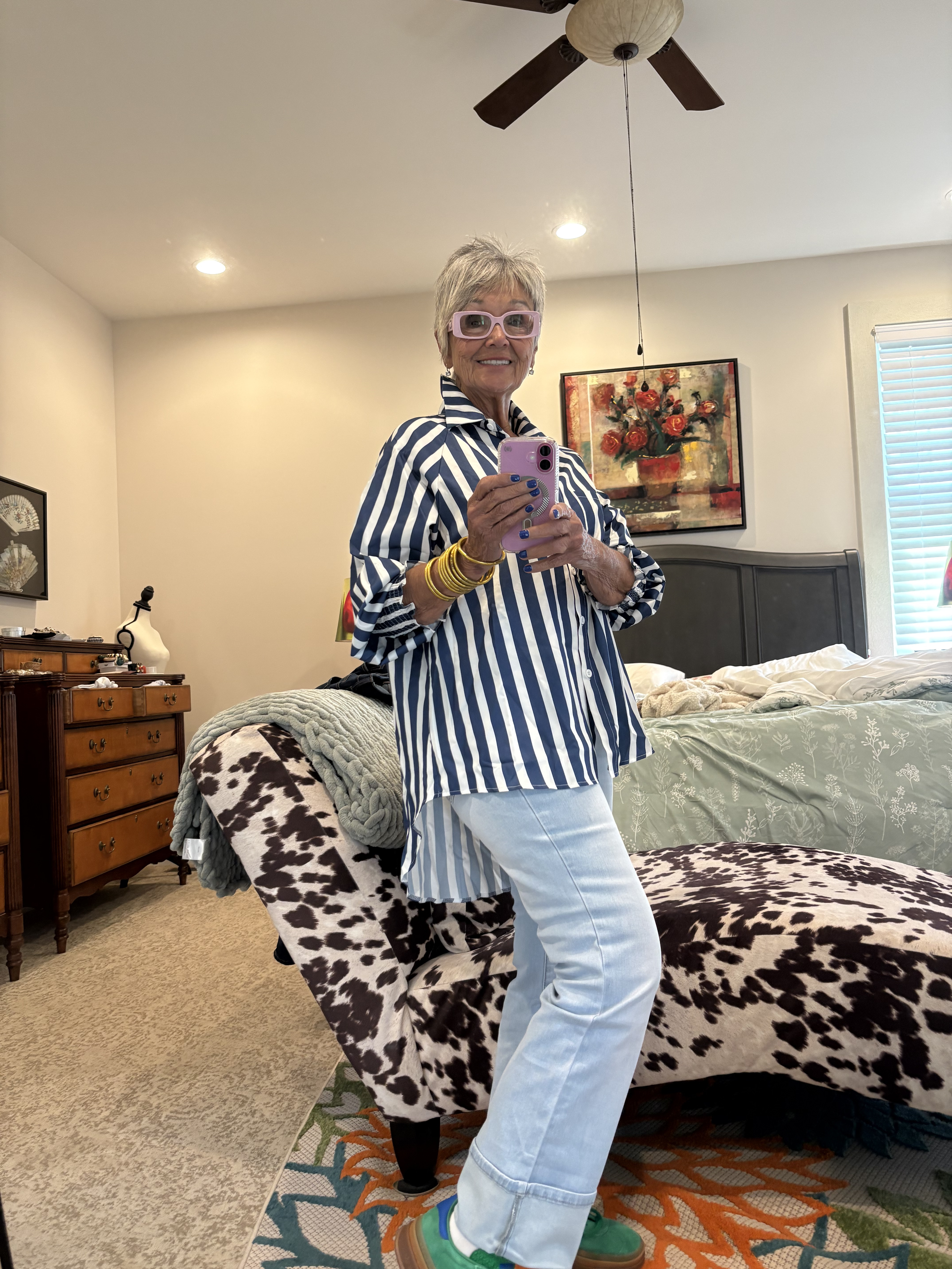 Mindy in a navy stripe shirt and white jeans, mirror selfie
